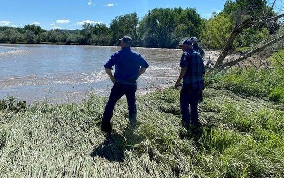 Commissioner Troy Downing stands on the bank of the Clark’s Fork of the Yellowstone speaking with a local rancher following the 2022 flooding.
